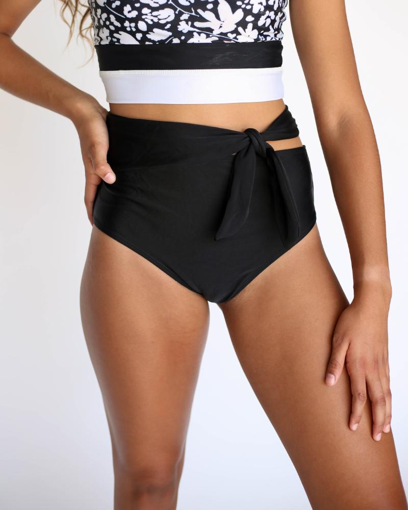 A studio image of a women wearing black swimsuit bottoms with a tie detail on the side.